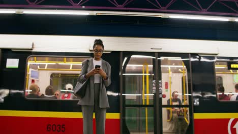 mujer usando el teléfono en una estación de metro