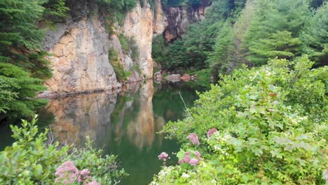 4k-drohnenvideo eines wunderschönen, von bäumen umgebenen bergteiches im smaragddorf in der nähe der kleinen schweiz, nc am 3. sommertag