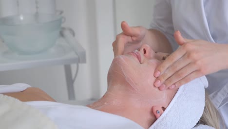 rejuvenating facial massage in cosmetology the girl is given a facial massage in the cosmetologist’s office. lifting effect and relaxation.