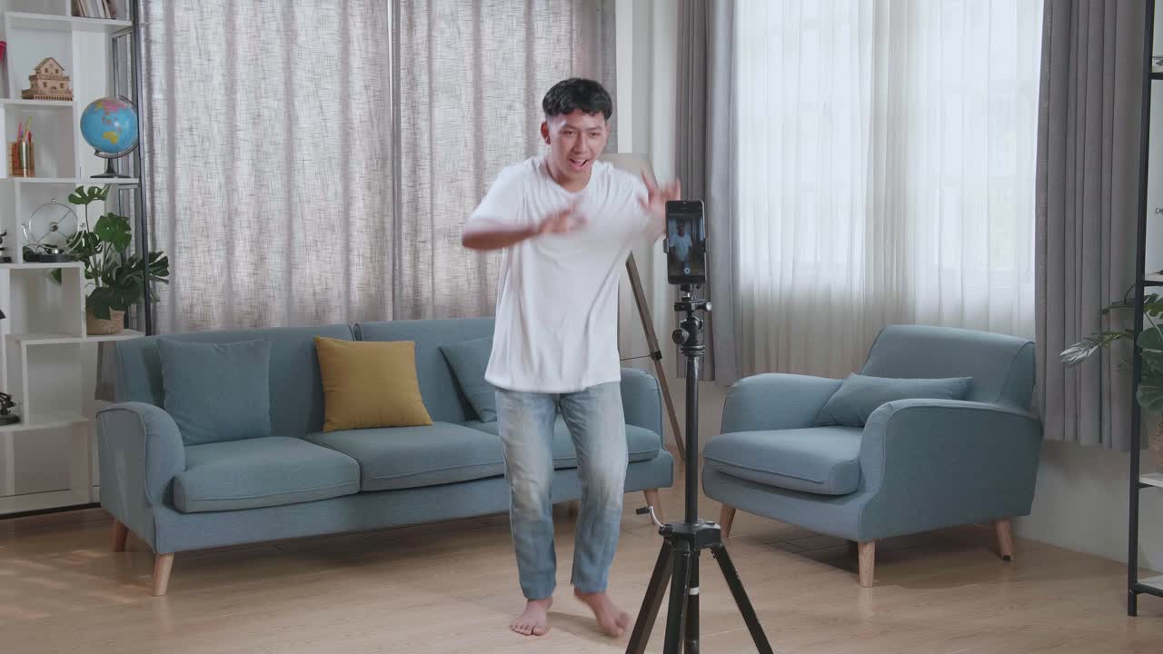Asian Boy Dancing While Shooting Video Content For Social Networks With A Smartphone Camera