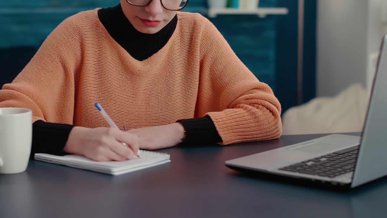 Portrait of college student taking notes on textbook