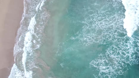 Vista-Aérea-Superior-Sobre-El-Agua-Clara-Y-Turquesa-Del-Océano-Que-Hace-Espuma-En-La-Orilla,-Lavando-La-Arena-Dorada-De-La-Playa,-Idílicas-Vacaciones-De-Verano-En-La-Isla-De-Hawaii