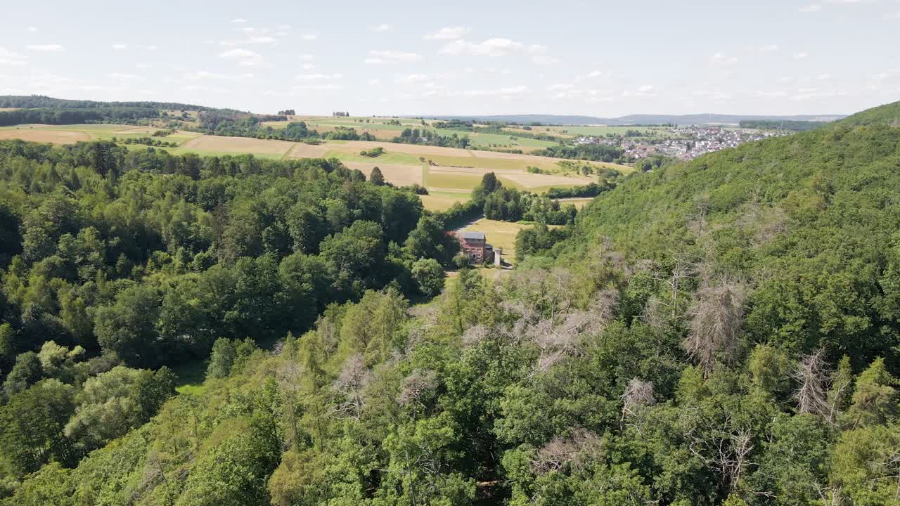 Ylilento metsän yli, paljastaen upean talon keskellä ei mitään, Hesse.