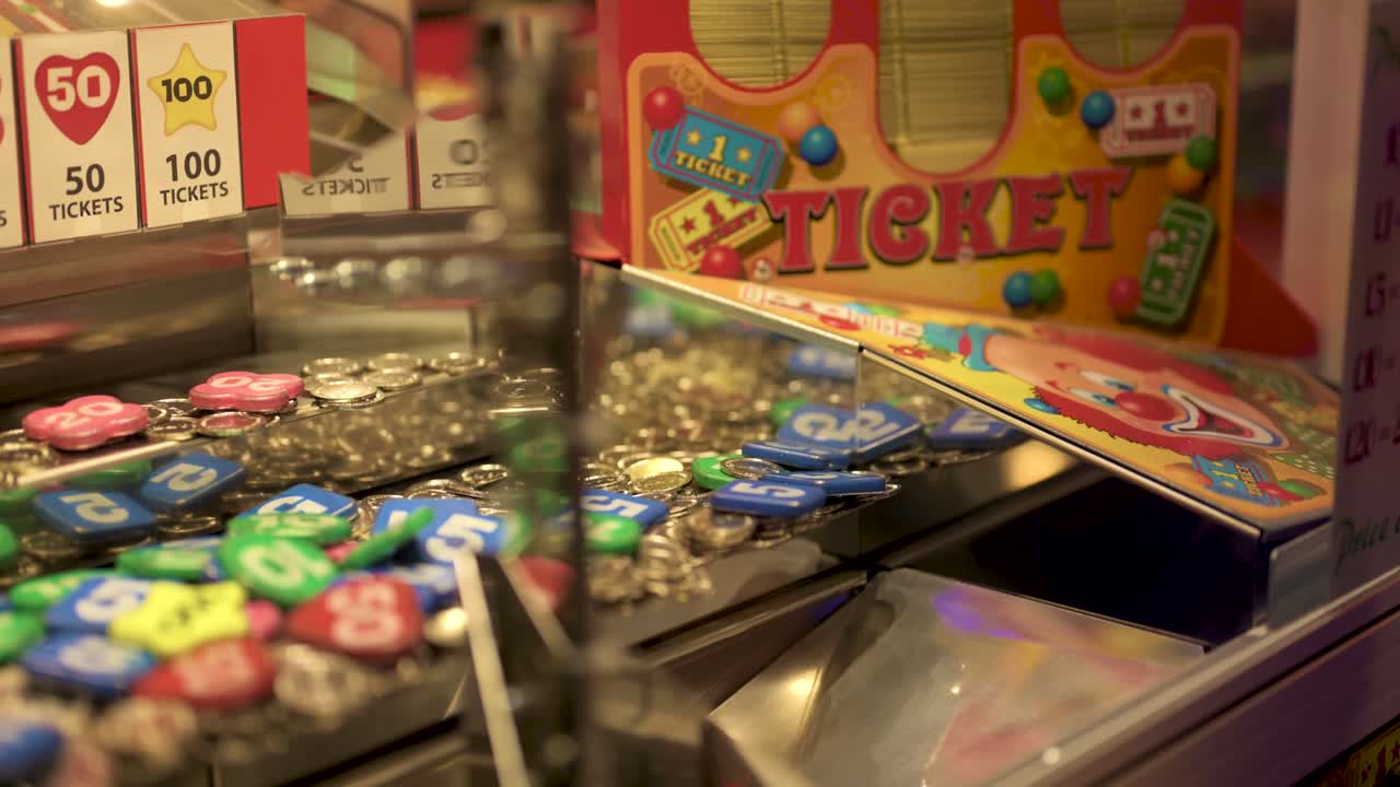 Arcade coin pusher dropping a 100 price, slow motion