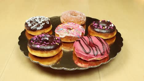 variety-of-sweet-donuts-on-a-golden-turntable-open-shot