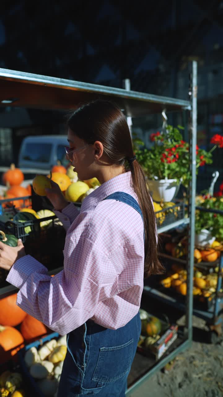 mujer comprando calabazas en un mercado de agricultores de otoño