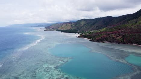 aerial rising over rugged coastline landscape, ocean, with coral reef in dili, timor-leste, southeast asia