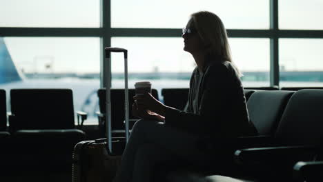 business woman drinking coffee in airport