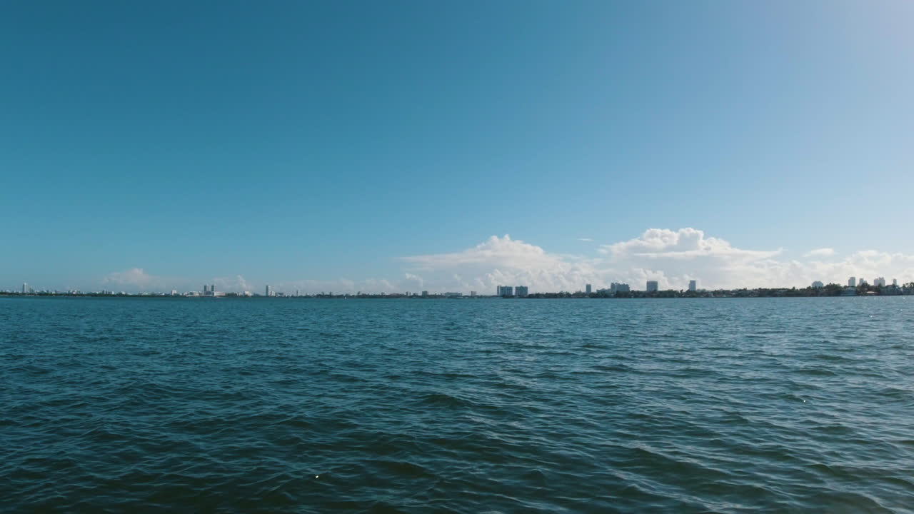 마이애미의 스카이라인은 푸른 물과 푸른 하늘 사이에 샌드위치 마이애미 플로리다의  ⁇ 은 날에 작은 보트의 관점에서