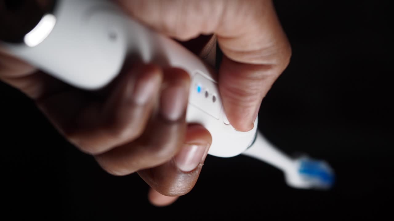 Person holding an electric toothbrush