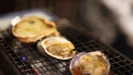 crabs grilling on a smoky charcoal barbecue