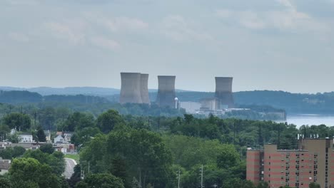nuclear cooling towers in suburb of american town. aerial wide shot. dangerous power plant producing energy. panorama view