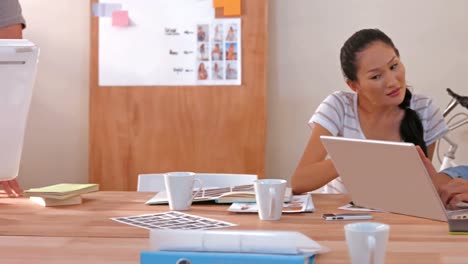 Creative-team-looking-at-computer-and-laptop-