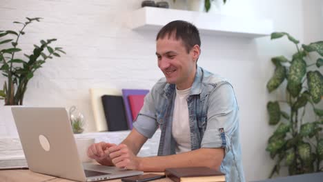 Tecnología,-Trabajo-Remoto-Y-Concepto-De-Estilo-De-Vida---Hombre-Feliz-Con-Computadora-Portátil-Teniendo-Video-Chat-Y-Saludando-Con-La-Mano-En-La-Oficina-De-Casa