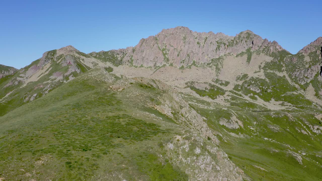 volando sobre las verdes laderas de las montañas en la cordillera de lagorai, italia, mientras los pájaros pasan volando