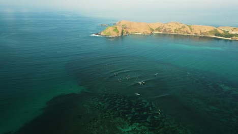 aerial over the coastline of surfers catching a big wave together near kuta in the south of lombok island, indonesia