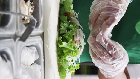 Vertical video of a cook preparing a healthy green wrap