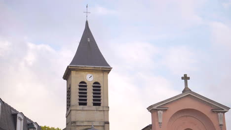daytime shot of sainte geneviève church steeple in asnières-sur-seine, consecrated in 1541.the bell tower stands against the sky, showcasing this small, historic church’s timeless french architecture.