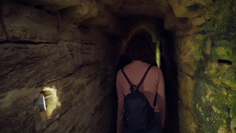 gente caminando explorando un largo y profundo túnel subterráneo de piedra, alcantarillas romanas en medina, cádiz, españa