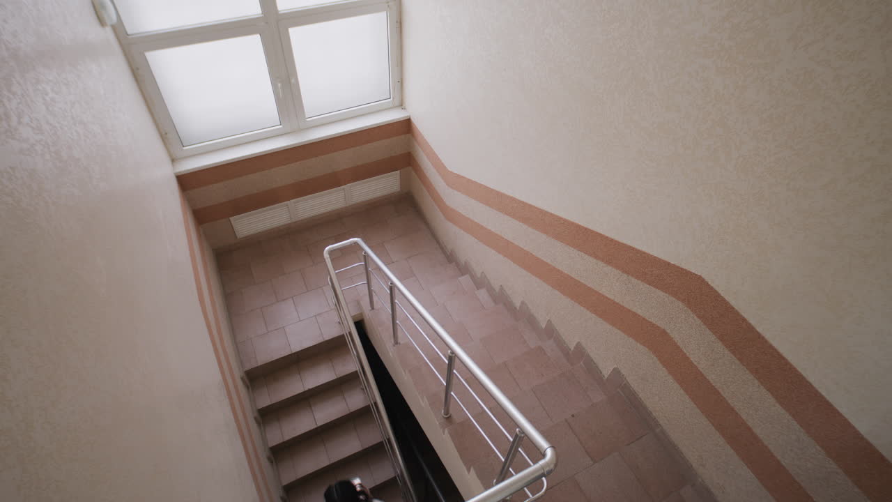 People walking up and down an indoor staircase in a building