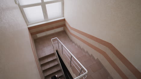 people walking up and down an indoor staircase in a building