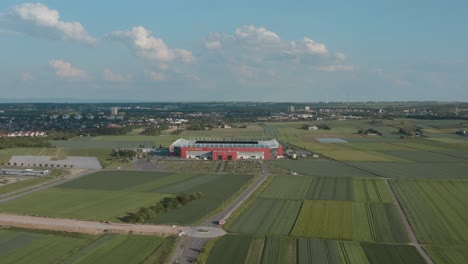 Drone---Aerial-shot-of-the-football-stadium-of-the-bundesliga-team-FSV-Mainz-05-with-field-in-the-foreground-on-a-sunny-day,-25p