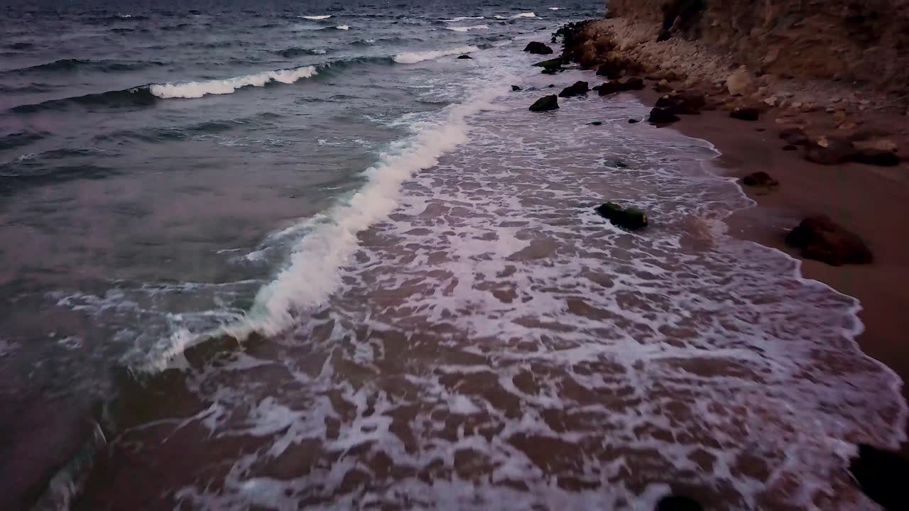 hermosas olas en la playa golpeando las rocas al atardecer