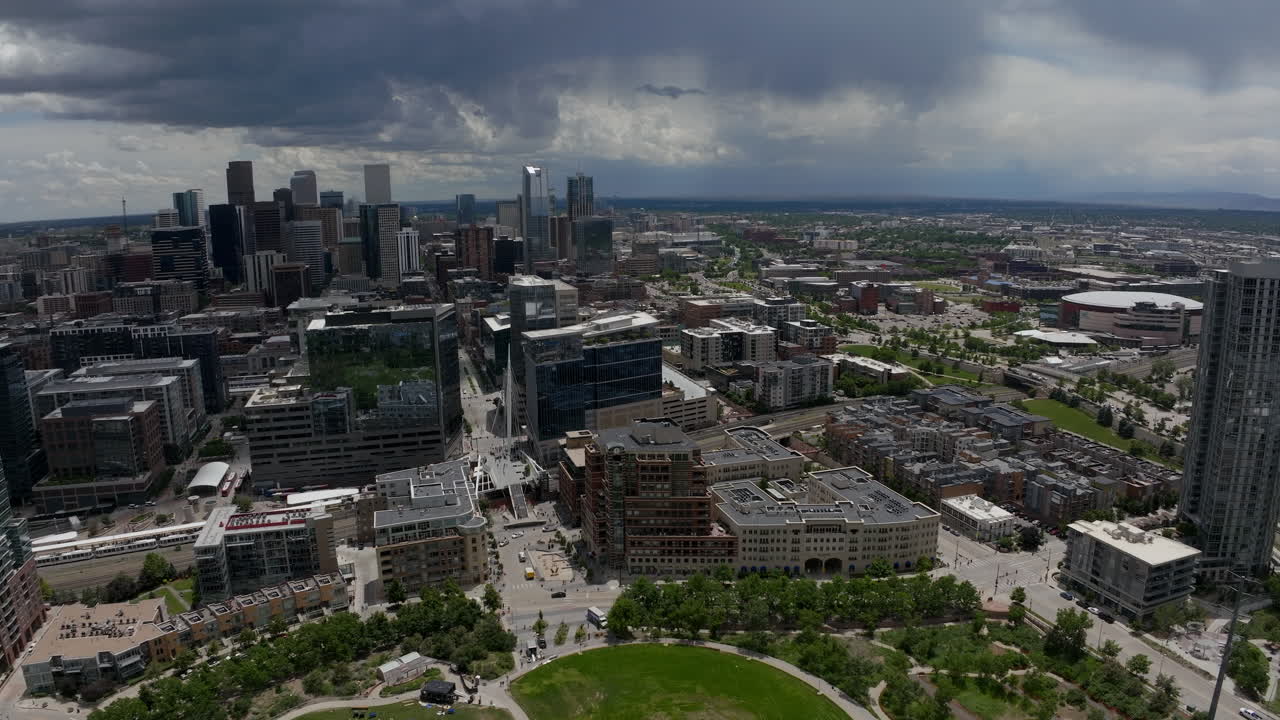 Downtown Denver Aerial Drone cinematic REI Ball Arena South Platte River Elitch Gardens cityscape with foothills Rocky Mountain Landscape Colorado cars traffic glass house summer circling motion