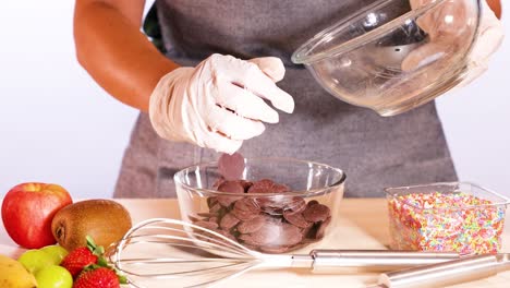 preparing chocolate discs with fresh fruits and sprinkles