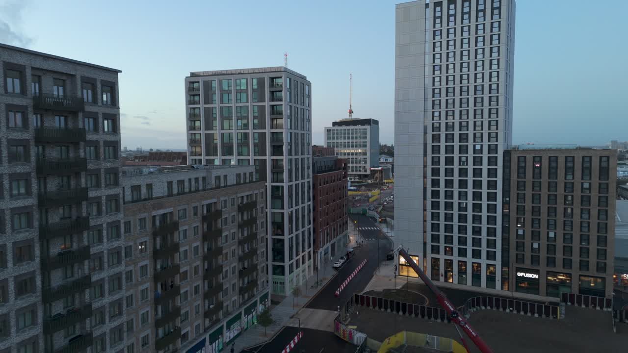 Drone flying through new build modern high rise residential buildings in urban city landscape
