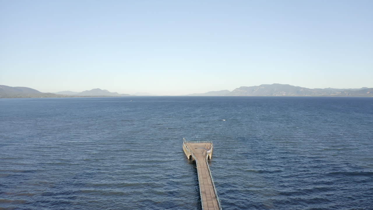 el avión orbita lentamente el muelle de hormigón en forma de abanico vacío en el mar egeo.