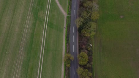 Eine-Landstraße-Mit-Grünen-Feldern-Und-Bäumen,-Die-Daneben-Laufen