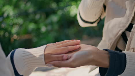 mother touching fingers little daughter on nature close up. woman playing girl