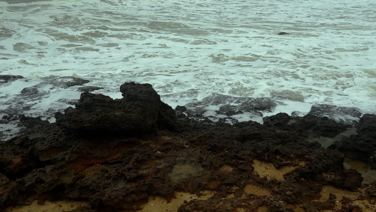 Onda del mare che si infrange su una roccia.