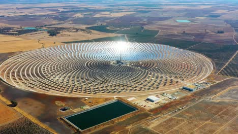 vista aérea de una gran planta de energía circular de paneles solares en españa. hay el reflejo del sol en los paneles que producen energía renovable - concepto de medio ambiente