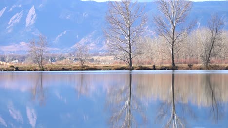 Woman-running-along-a-lake-in-slow-motion-against-a-background-of-mountains