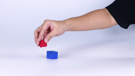 hands manipulate red and blue geometric blocks