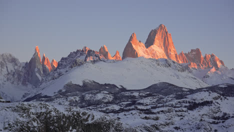 los picos del monte fitzroy y cerro torre temprano en la mañana con una brillante luz naranja en la patagonia, argentina