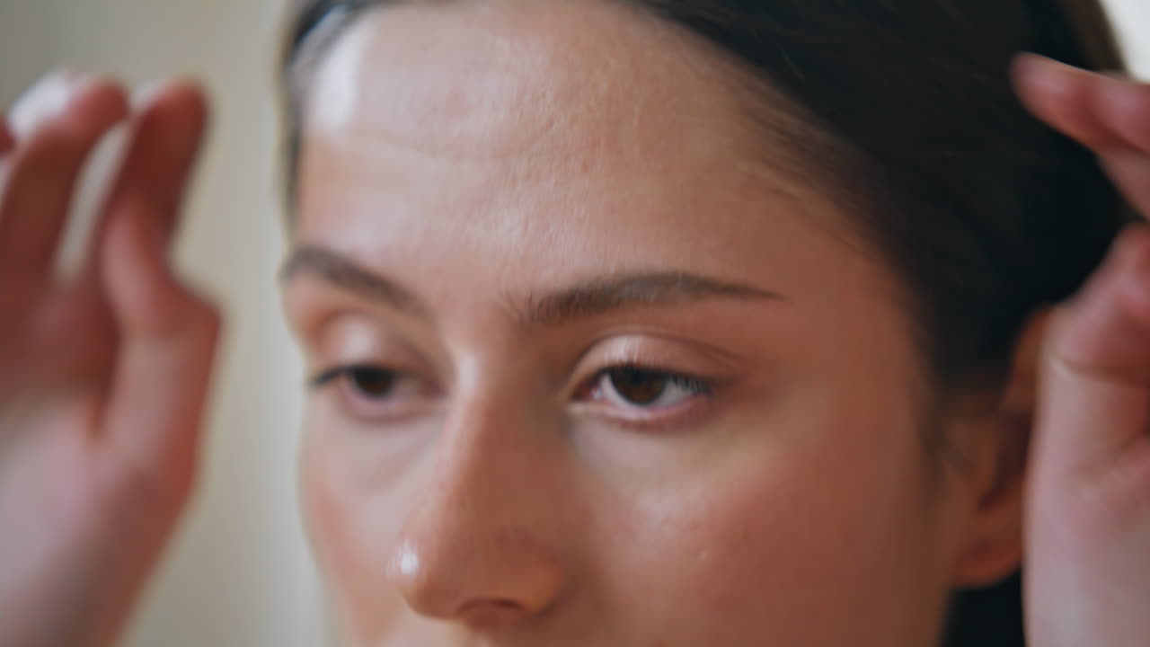 Closeup girl massaging facial skin under-eye area indoors. Woman home skincare