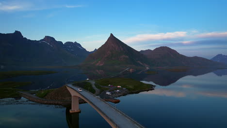 Conducción-De-Automóviles-Sobre-Puentes-Famosos-En-La-Isla-De-Lofoten,-Fredvang,-Con-Montañas-Reflectantes-En-La-Superficie