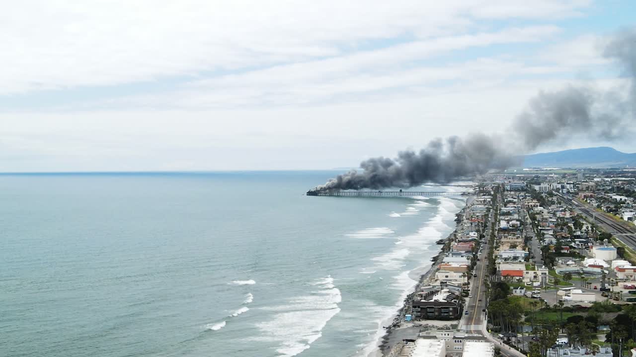 pier on fire with black smoke