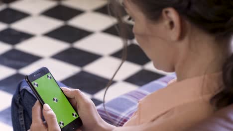 mujer usando un teléfono inteligente con una pantalla verde