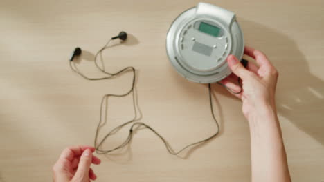 mujer usando un reproductor de cd vintage y auriculares