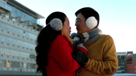 happy mature couple in winter clothes embracing