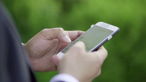 cropped shot of businessman texting by smartphone outdoor