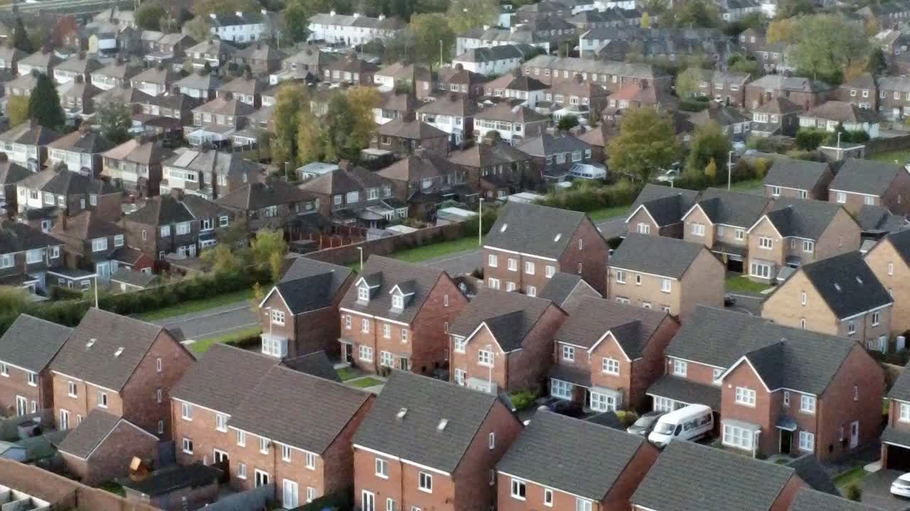 Property ladder new British housing estate aerial view overlooking rooftops closeup left dolly