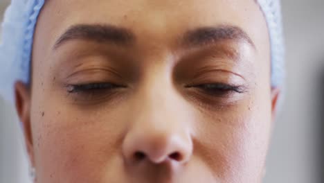 video close up portrait of the eyes of smiling biracial female medical worker in surgical cap