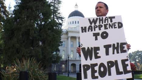 Male-Political-Protester-with-What-Happened-to-We-The-People-Sign-Slider-Dolly-Tracking-Shot