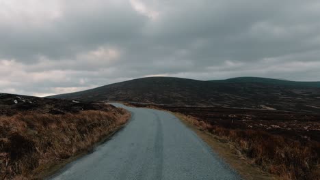 pov, point of view drive through an amazing, and surreal scenery on an asphalt road with hills on a prairie