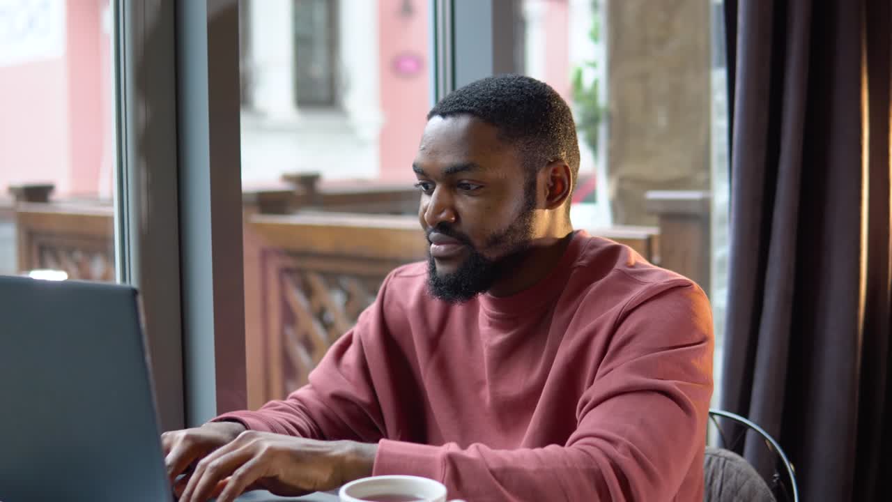 Man working with the laptop in the restaurant. Freelance work from cafe